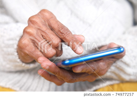 senior women hand using smart phone close up senior women hand using smart phone close up 74977257