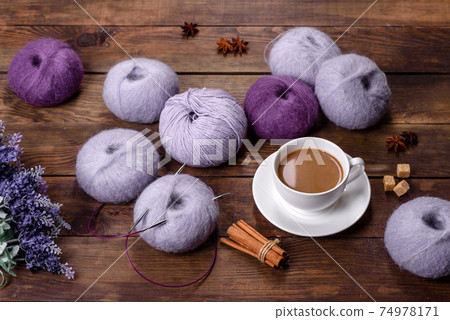 Tangles of wool threads and spokes with a cup of coffee and sugar on a wooden background 74978171