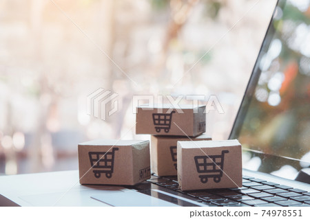 Shopping online. Credit card and cardboard box with a shopping cart logo on laptop keyboard. Shopping service on The online web. offers home delivery 74978551