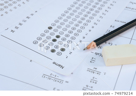 Pencil and eraser on answer sheets or Standardized test form with answers bubbled. multiple choice answer sheet Pencil and eraser on answer sheets or Standardized test form with answers bubbled. multiple choice answer sheet 74979214