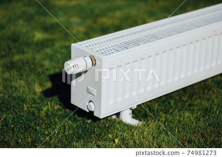 radiator on green lawn, ecological heating concept radiator on green lawn, ecological heating concept 74981273