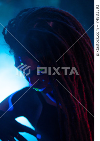 Cocky Girl with Dreadlocks in Ultraviolet neon light with Foggy Background. Bodyart Cocky Girl with Dreadlocks in Ultraviolet neon light with Foggy Background. Bodyart 74981393