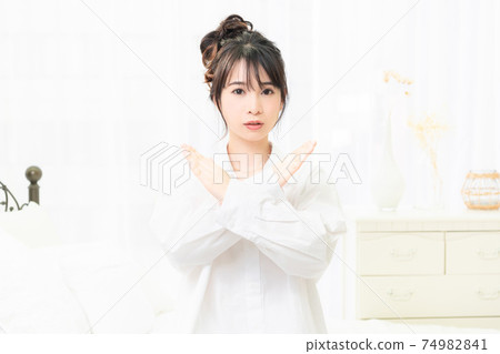 一件白襯衫,在房間裡做NG手勢的年輕女子 一件白襯衫,在房間裡做NG手勢的年輕女子 74982841