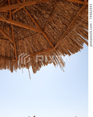 A projection of a straw canopy against a blue sky A projection of a straw canopy against a blue sky 74982843