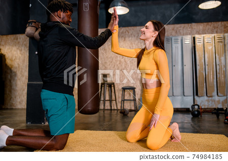 a black man and a girl are engaged in sports. they beat off a five to each other a black man and a girl are engaged in sports. they beat off a five to each other 74984185