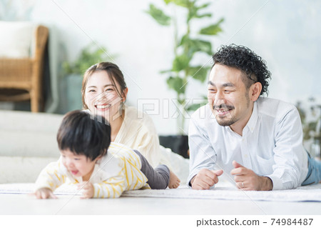 A family of three playing in the living room A family of three playing in the living room 74984487