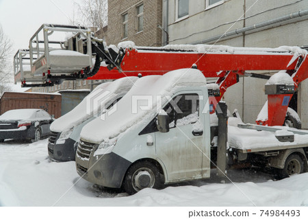 snow-covered lifting equipment. aerial platform is idle, the construction work is not carried out. 74984493