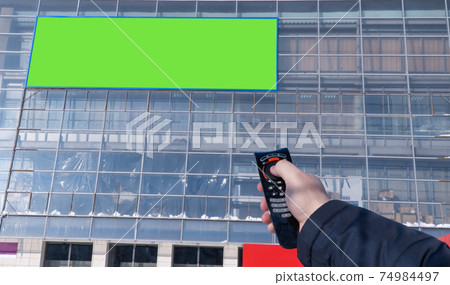 advertising screen on the street is switched from the remote control. selective focus. advertising screen on the street is switched from the remote control. selective focus. 74984497