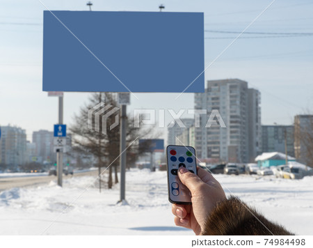 advertising screen on the street is switched from the remote control. selective focus. advertising screen on the street is switched from the remote control. selective focus. 74984498