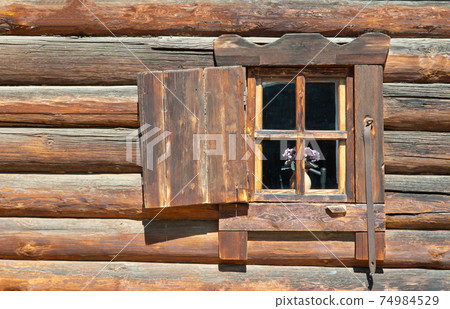 casement window on an old log wall. window of the village hut. casement window on an old log wall. window of the village hut. 74984529