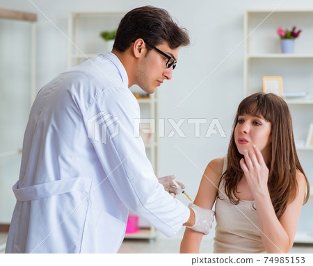 Doctor examining the skin of female patient 74985153