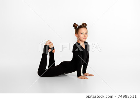 child girl in black sportswear doing stretching. child girl in black sportswear doing stretching. 74985511