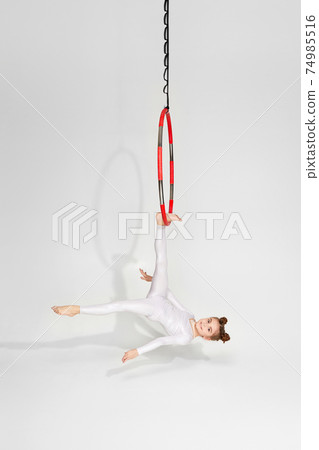 Girl gymnast shows an acrobatic performance Girl gymnast shows an acrobatic performance 74985516