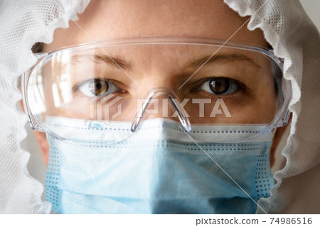 Doctor or nurse in professional suit due to COVID-19 coronavirus close-up Doctor or nurse in professional suit due to COVID-19 coronavirus close-up 74986516