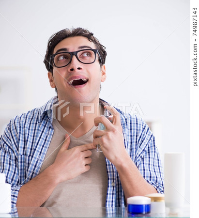 Young man is getting prepared for working day in bathroom Young man is getting prepared for working day in bathroom 74987143