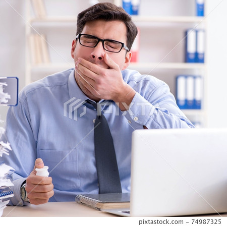 Extremely busy businessman working in office Extremely busy businessman working in office 74987325