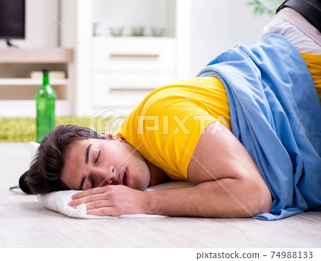 Man with mess at home after house party Man with mess at home after house party 74988133