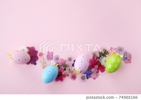 Easter background. Frame of fllowers and eggs on pink background. Flat lay, top view Easter background. Frame of fllowers and eggs on pink background. Flat lay, top view 74988166