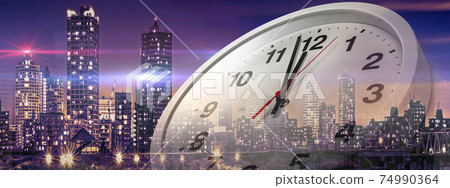 A clock pointing a little before 12 o'clock in the evening and the city at night. Image of last train, overtime or New Year's countdown 74990364