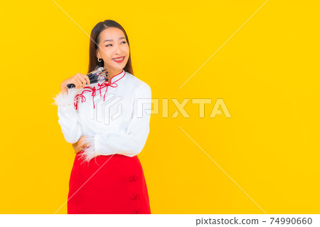 Portrait beautiful young asian woman with make up brush Portrait beautiful young asian woman with make up brush 74990660