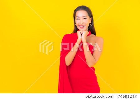 Portrait beautiful young asian woman smile with action on yellow background Portrait beautiful young asian woman smile with action on yellow background 74991287