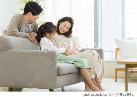 Family pregnant woman spending time in the living room Family pregnant woman spending time in the living room 74992942