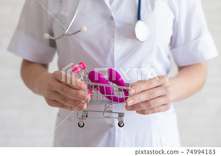 The faceless gynecologist recommends buying a clitoral vaginal vibrator to maintain women's health. The doctor holds a mini trolley and a masturbator for vivid orgasms. The faceless gynecologist recommends buying a clitoral vaginal vibrator to maintain women's health. The doctor holds a mini trolley and a masturbator for vivid orgasms. 74994183