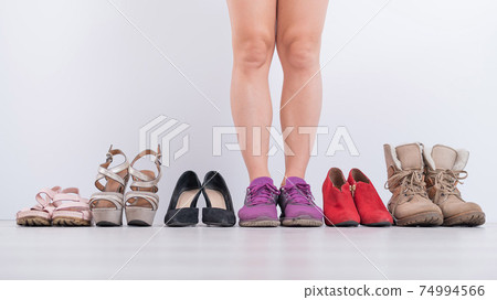 The woman prefers sneakers. Collection of women's shoes in a row on a white background The woman prefers sneakers. Collection of women's shoes in a row on a white background 74994566