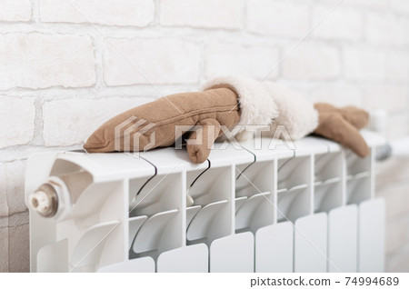 Women's mittens dry on the radiator in winter Women's mittens dry on the radiator in winter 74994689