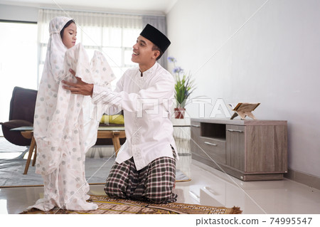 muslim father teaching her daughter how to pray at home muslim father teaching her daughter how to pray at home 74995547