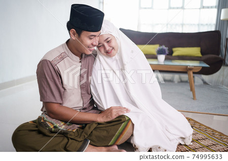 asian muslim couple after praying together at home 74995633