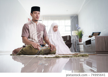 muslim husband and wife praying jamaah together at home muslim husband and wife praying jamaah together at home 74995641