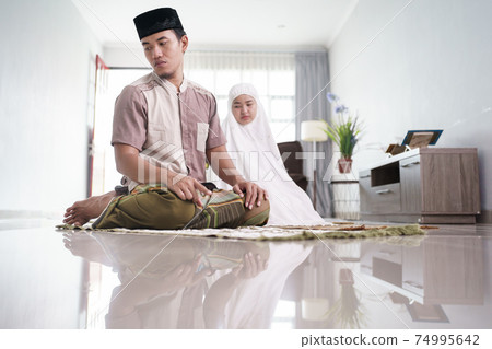muslim husband and wife praying jamaah together at home muslim husband and wife praying jamaah together at home 74995642