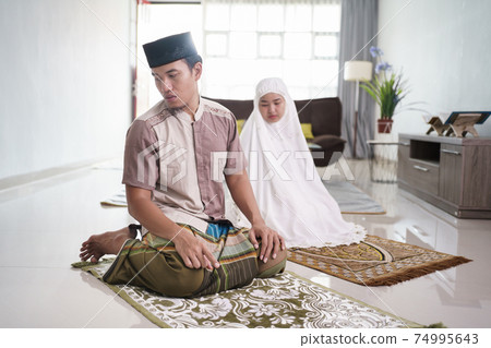 muslim husband and wife praying jamaah together at home muslim husband and wife praying jamaah together at home 74995643