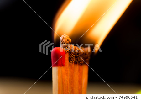 close up the line of matchstick be on fire make a big flame in dark background. close up the line of matchstick be on fire make a big flame in dark background. 74996541