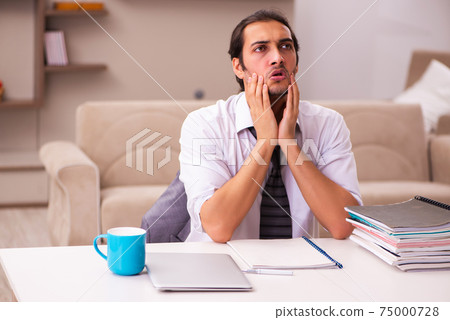 Young male employee working from home during pandemic 75000728