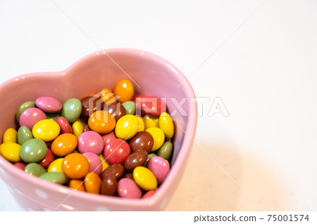 Colorful chocolate in a heart-shaped bowl Colorful chocolate in a heart-shaped bowl 75001574