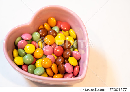 Colorful chocolate in a heart-shaped bowl Colorful chocolate in a heart-shaped bowl 75001577