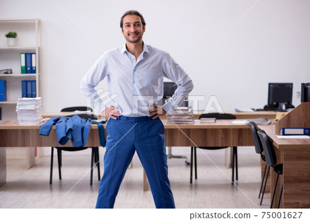 Young male employee doing sport exercises during break 75001627