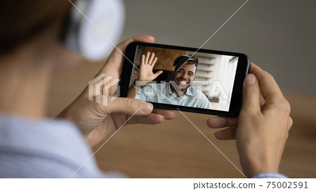 Woman speak on video call on cellphone with friend Woman speak on video call on cellphone with friend 75002591