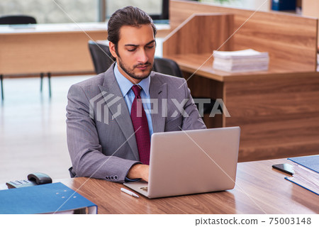 Young male employee working in the office Young male employee working in the office 75003148