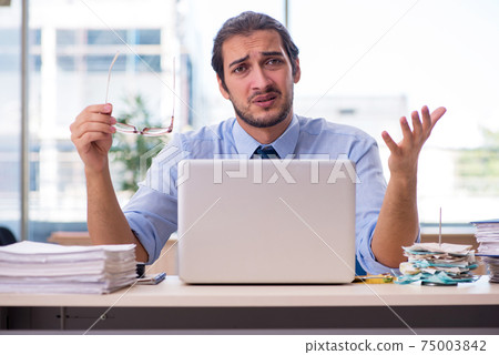 Young male accountant working in the office Young male accountant working in the office 75003842