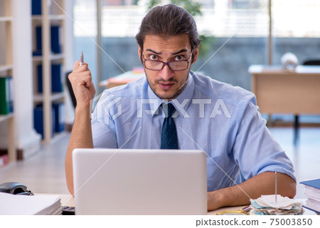 Young male accountant working in the office Young male accountant working in the office 75003850