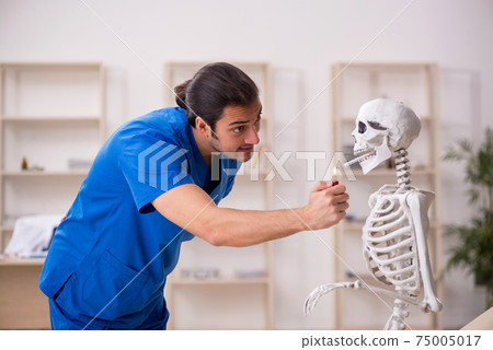 Young male doctor and skeleton patient in antismoking concept Young male doctor and skeleton patient in antismoking concept 75005017