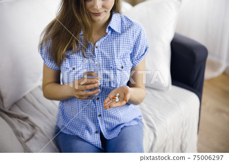 Close-up woman holding pills time to take medications, cure for headache, high blood pressure or cholesterol level remedy pain killer drugs. Medicine concept 75006297