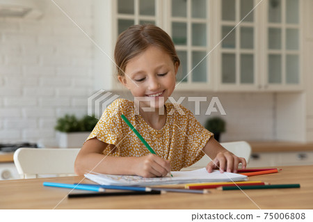 Inspired little girl sit at kitchen table drawing colorful picture 75006808