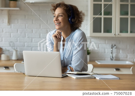 Young lady in headphones rest from studying at home kitchen Young lady in headphones rest from studying at home kitchen 75007028