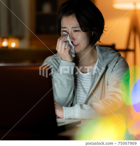 一名年輕女子在午夜廣場的客廳裡看電影時哭泣 一名年輕女子在午夜廣場的客廳裡看電影時哭泣 75007909