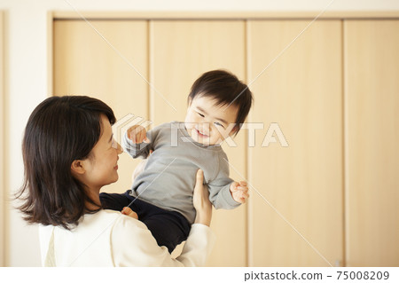 媽媽在客廳裡抱著一個嬰兒 媽媽在客廳裡抱著一個嬰兒 75008209