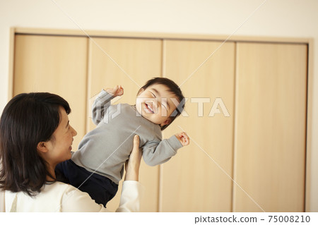 媽媽在客廳裡抱著一個嬰兒 媽媽在客廳裡抱著一個嬰兒 75008210